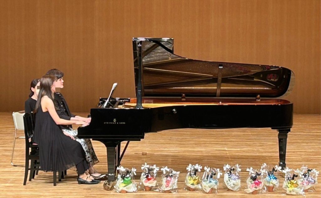 発表会で講師と生徒が連弾している様子